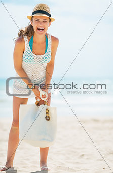Full length portrait of happy young woman in hat and with bag on