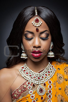 Young Indian woman in traditional clothing with bridal makeup and jewelry