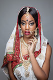 Young Indian woman in traditional clothing with bridal makeup and jewelry