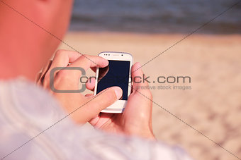 man with phone on the beach