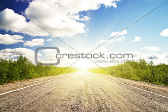 Old asphalt road in green sunset meadow