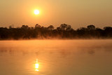 Sunrise at Kavango river with mist on the water surface