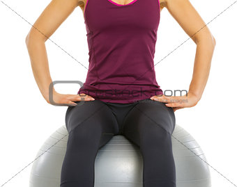 Closeup on fitness young woman sitting on fitness ball