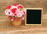 gold picture frame with paper flowers on wooden background 