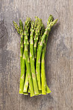 bunch of fresh green asparagus on old wood board