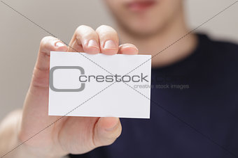 adult man hand  holding empty business card in front of camera