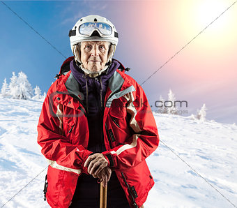 Old woman standing in winter ski goggles on snow holiday in mountains. With clipping path.