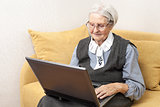 Senior woman using laptop computer while sitting on sofa