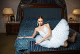 Ballerina lying down on bed and daydreaming in luxury interior