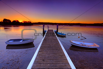 Sunset moorings and boat jetty in a little cove Australia