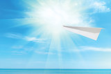 paper plane against the blue sky and sea