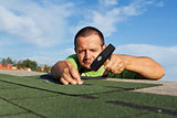 Man installing or repairing roof with bitumen shingles