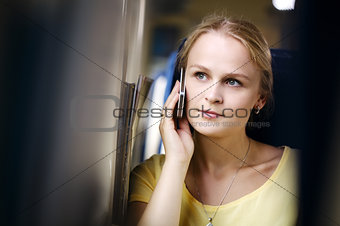 Attractive woman listening to a call on her mobile travelling by train