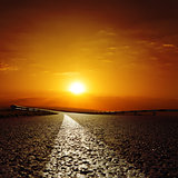 asphalt road to red sunset