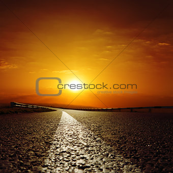 asphalt road to red sunset