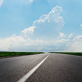 asphalt road to horizon under cloudy sky