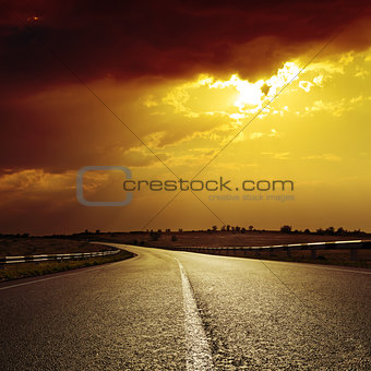 asphalt road to dramatic sunset