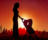 Mother and baby carriage on sunset background 