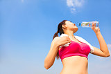sporty woman drinking water  bottle after jogging or running
