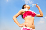 young woman drinking water after running session