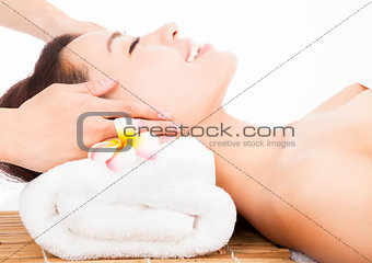 relaxing massage of face for asian woman in spa salon