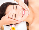 massage of face for asian woman in spa salon