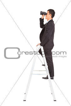 businessman using a pair of binoculars standing  on stair