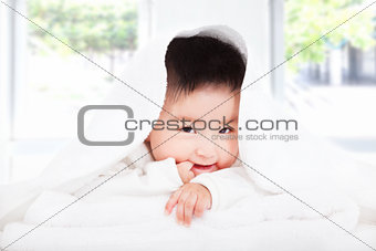 asian baby sucking  finger under  blanket or towel