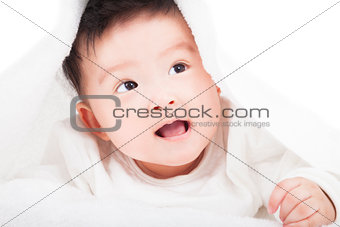 cute baby smiling under a white blanket or towel