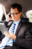 businessman working with tablet and smart phone in the car
