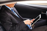 businessman touching tablet in the car