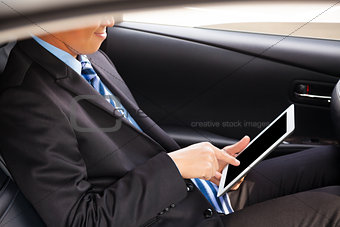 businessman touching tablet in the car
