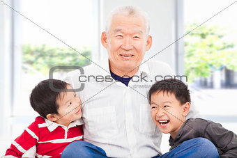 happy grandfather and grandchildren playing at home 