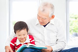 grandfather reading a story book for his grandson