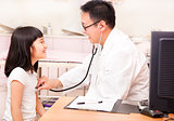 Asian male pediatrician examining little girl