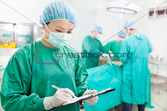 woman Surgeons writing records on form