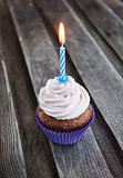 Tasty birthday cupcake with candle