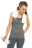 Tired fitness young woman with towel and bottle of water