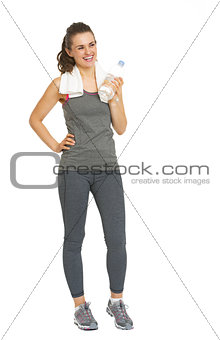 Full length portrait of smiling fitness young woman with bottle 