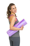 Portrait of happy fitness young woman with fitness mat