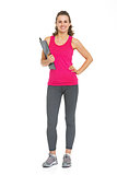 Full length portrait of smiling fitness young woman with clipboa