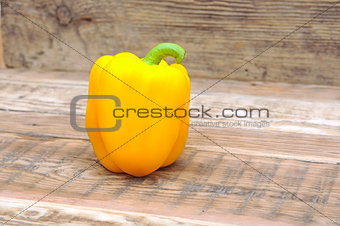 Yellow paprika on wooden background