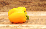 Yellow paprika on wooden background 