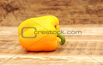 Yellow paprika on wooden background 