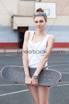 beautiful sexy lady in jeans shorts with skateboard at sport cou