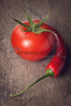 fresh chilli pepper and tomato on wood table