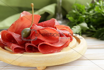 Smoked meat bresaola snack on a cutting board