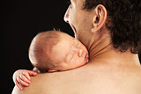 Newborn boy sleeping on his dad's shoulder