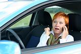 Red-haired woman with mobile-phone in a car. 