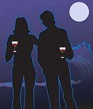 couple standing in moonlight and holding wine glasses